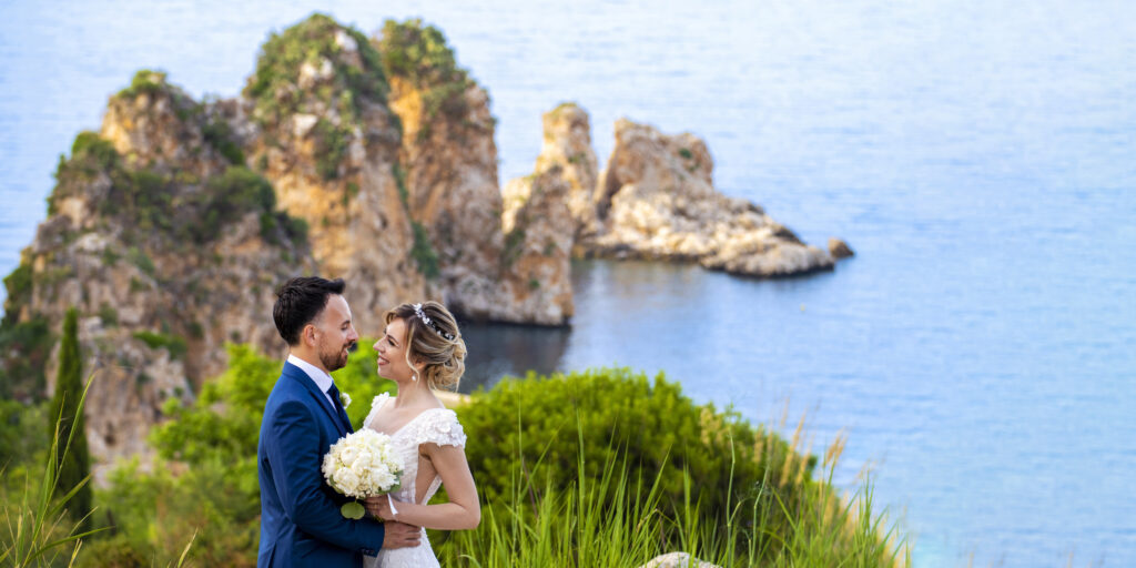 Foto di matrimonio a Scopello, ai faraglioni di Scopello, Castellammare del Golfo, in provincia di Trapani. Due sposi con dietro i faraglioni di Scopello.