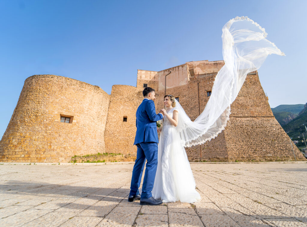 Foto di matrimonio a Castellammare del Golfo in provincia di Trapani. Due sposi con dietro il castello di Castellammare del Golfo.